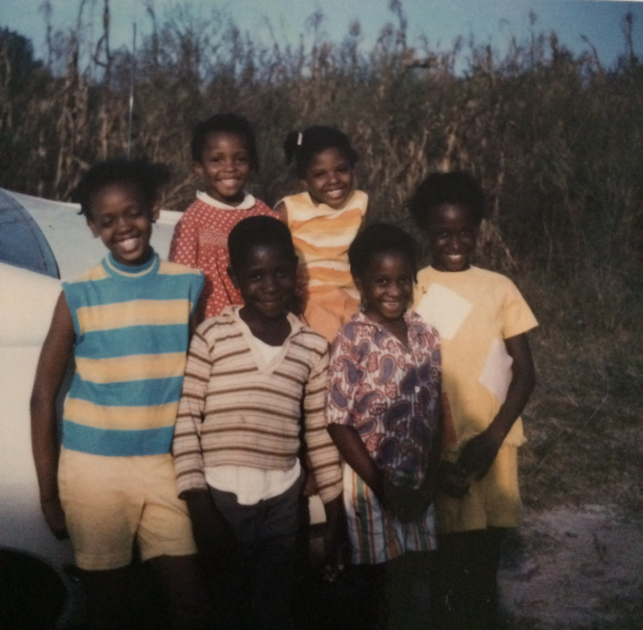 Vintage family photo — six children by a car